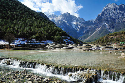 Scenic view of waterfall against sky