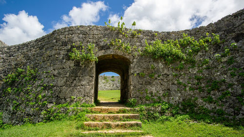 Built structure by plants against sky