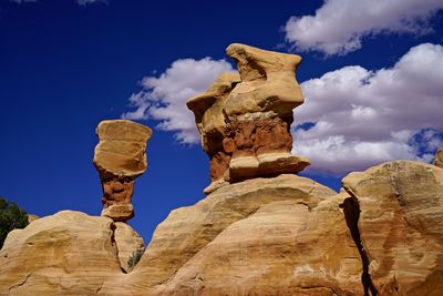 Low angle view of rock formation against cloudy sky