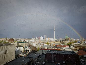 Rainbow over cityscape seen through window