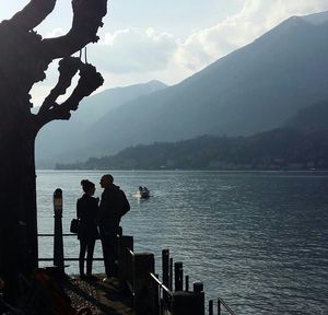 People standing on mountain by sea against sky