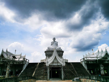 Low angle view of buddhist temple against cloudy sky