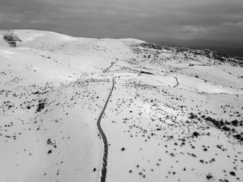Scenic view of snow covered land against sky