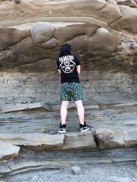 Rear view of woman standing on rock