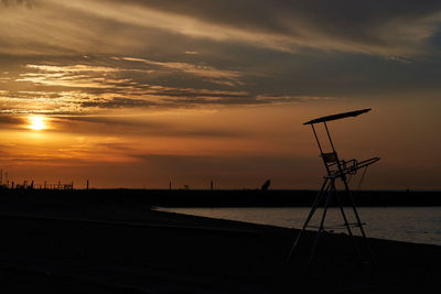 Scenic view of silhouette beach against sky during sunset