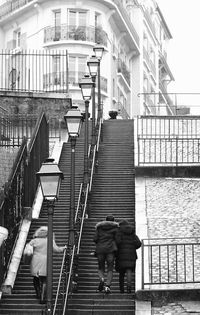 Rear view of people walking on staircase