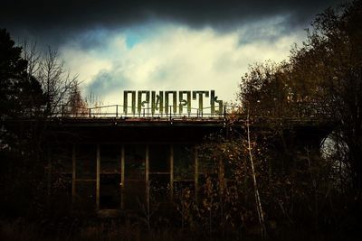 Bridge over river against cloudy sky