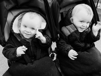 Close-up of happy brothers in baby stroller