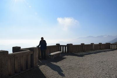 Silhouette man standing at observation point against blue sky