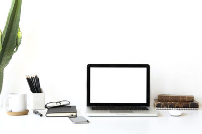 Close-up of laptop on table against white background