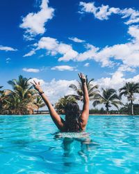 Man swimming in pool against blue sky