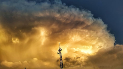 Low angle view of communications tower against sky during sunset