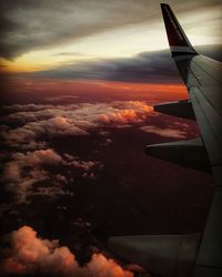 Aerial view of airplane wing over clouds