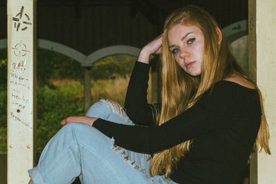 Portrait of a young woman sitting outdoors