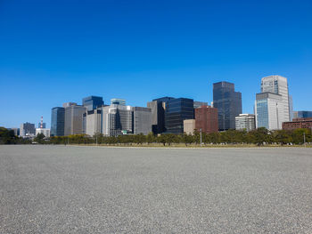 Street by buildings against clear sky