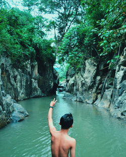 Man standing on rock against trees