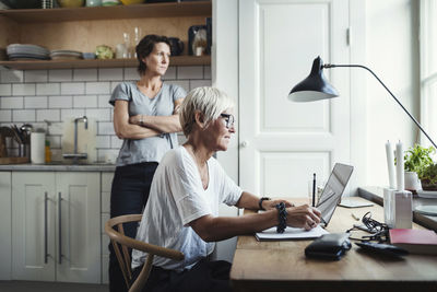 Friends sitting on table at home