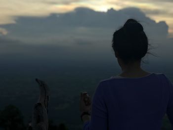 Rear view of woman looking at sea against sky
