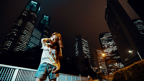 Low angle view of illuminated buildings against sky at night