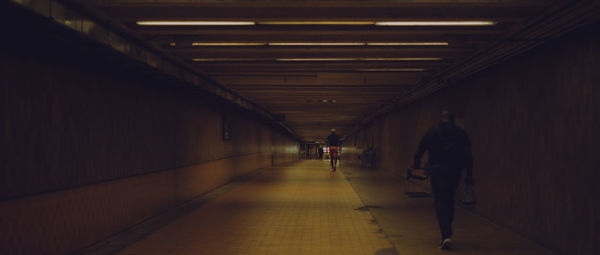 Rear view of people walking in corridor of building