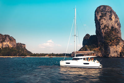 Sailboat on rock by sea against sky