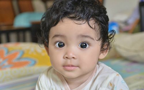 Close-up portrait of cute baby girl at home