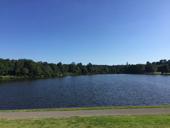 Scenic view of lake against clear blue sky