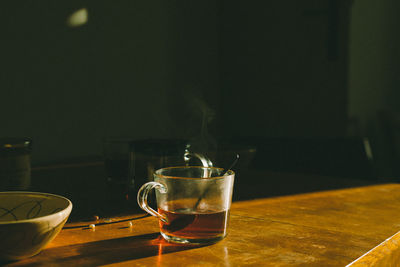 Close-up of tea cup on table on early morning with sunlight.