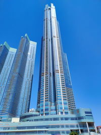 Low angle view of modern buildings against clear blue sky