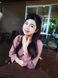 Portrait of young woman sitting on table