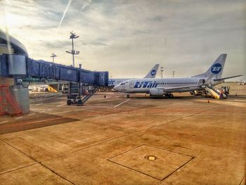 Airplane on airport runway against sky