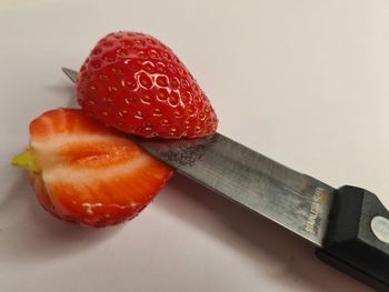 Close-up of strawberry on table against white background