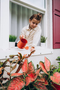 Girl watering plants from a watering can