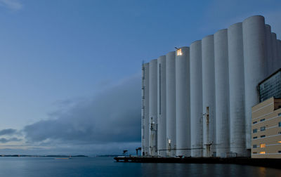 Panoramic view of silo and  sea against sky at dusk