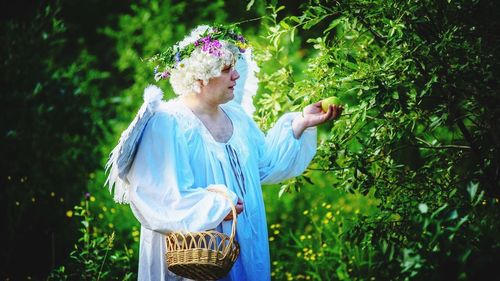 Person dressed as angel picking apples