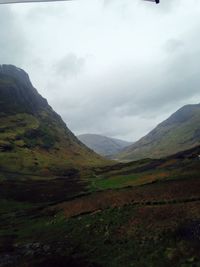 Scenic view of mountains against cloudy sky