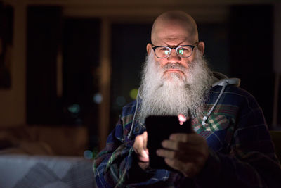 Portrait of man holding eyeglasses