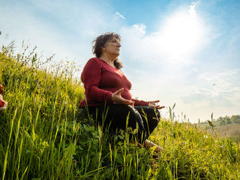 Senior youthful woman meditating in nature