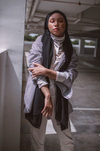 Young woman wearing headscarf while standing in parking garage