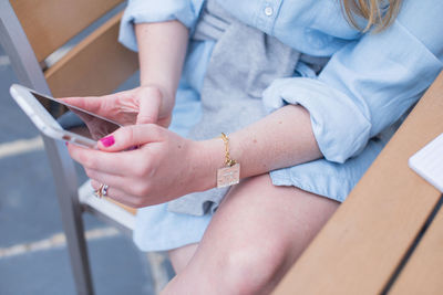 Midsection of woman using mobile phone