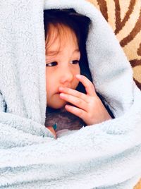 Close-up of thoughtful girl sitting on sofa at home