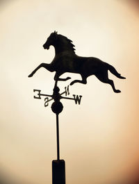 Low angle view of birds on weather vane