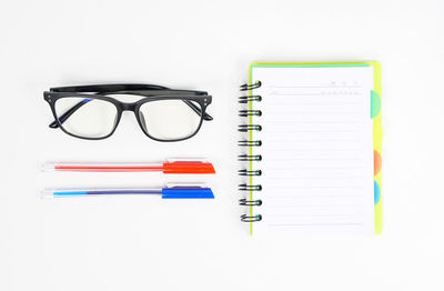 Directly above shot of eyeglasses on book against white background