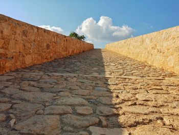 Surface level of footpath against sky