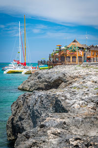 Sailboats on sea shore against sky