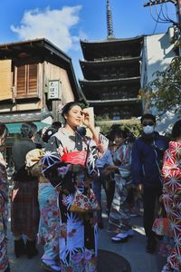 Beautiful young woman in kimono standing in city