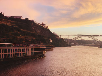 Bridge over river against sky during sunset