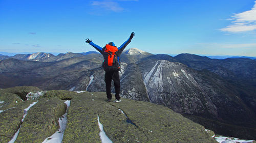 Rear view of boy on rock against sky