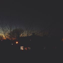 Low angle view of bare trees against sky at dusk