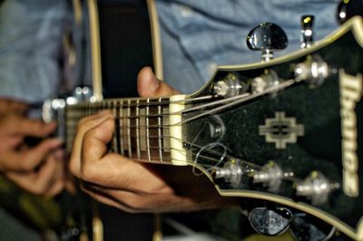 Midsection of man playing guitar